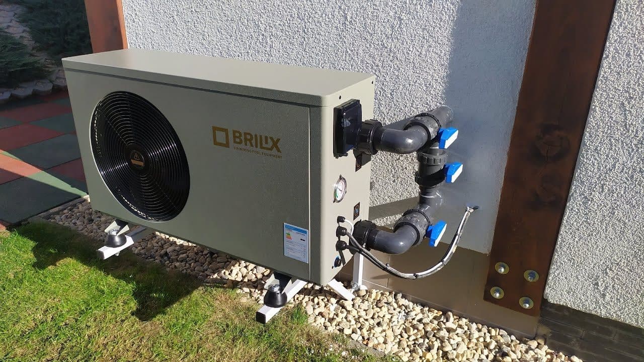 Heat pump installed on a gravel base next to a house